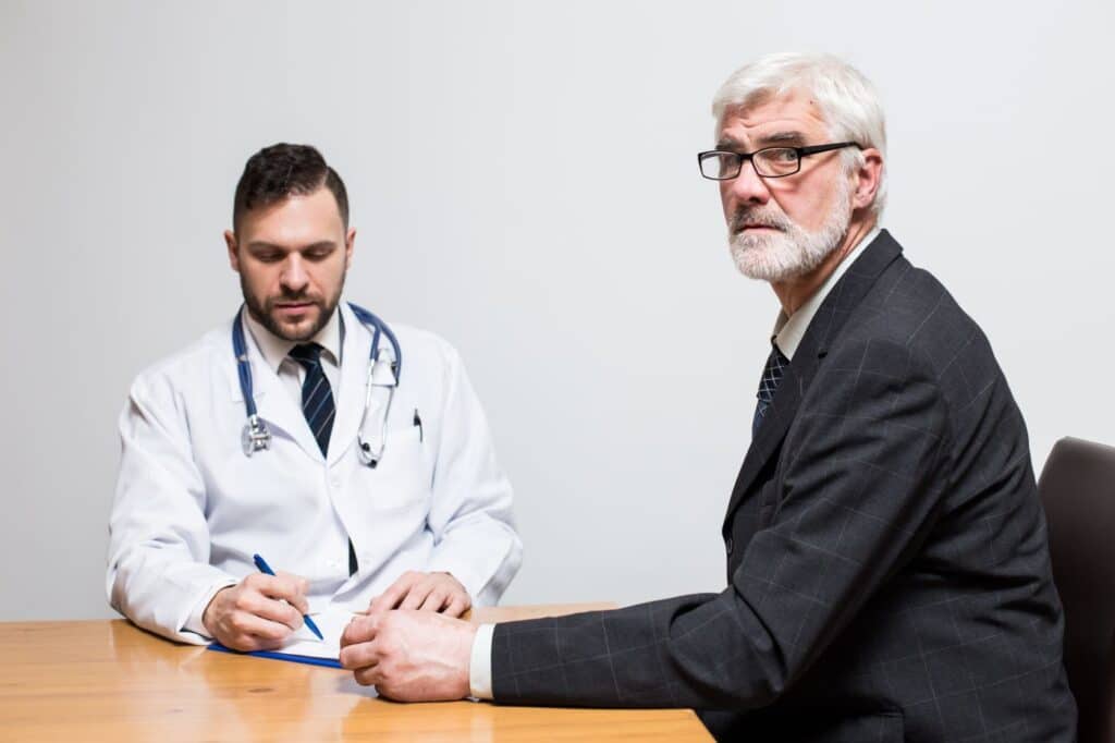 Homem maduro em consultório questionando se a doença de peyronie pode desaparecer Homem maduro em consultório questionando se a doença de peyronie pode desaparecer.