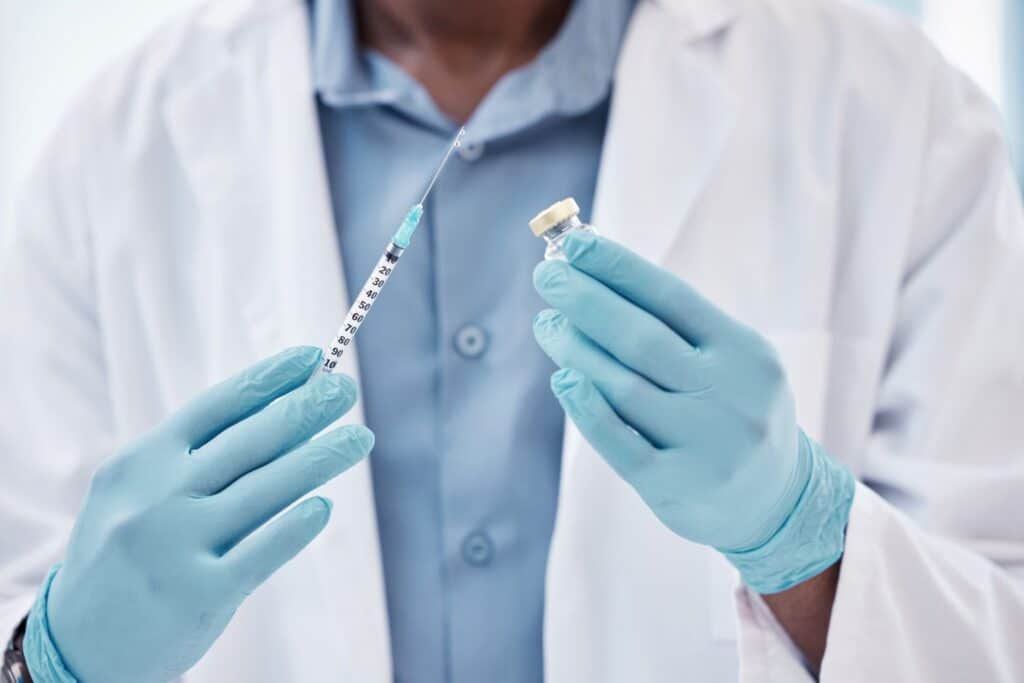 Médico com seringa em mãos, preparado para procedimento de harmonização peniana, simbolizando segurança e precisão.