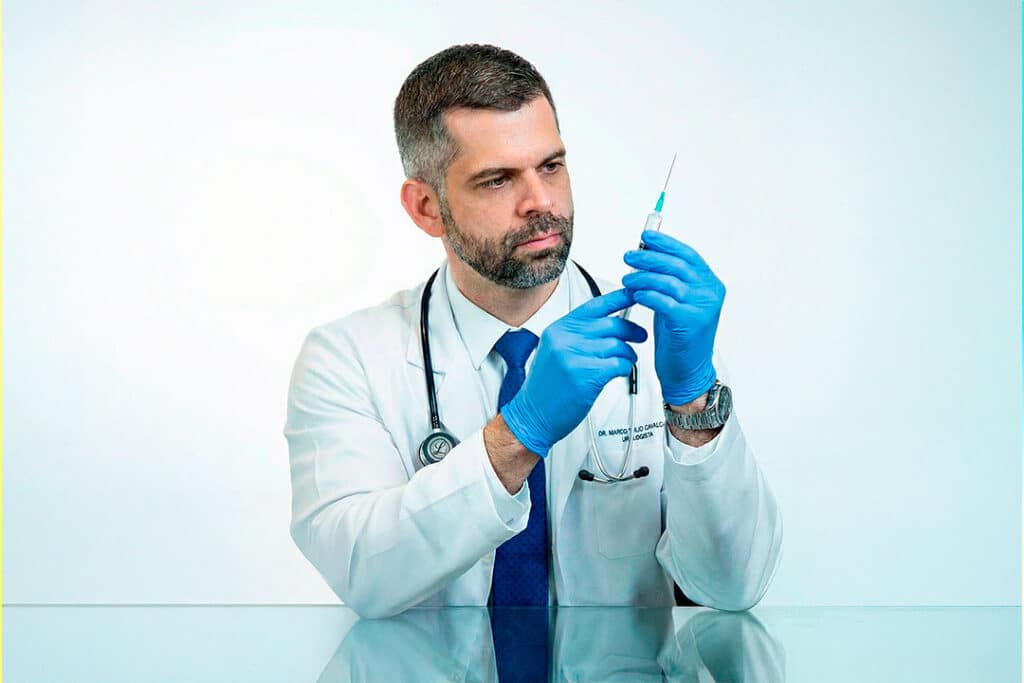 Dr Marco Túlio Cavalcanti observa seringa para procedimento de preenchimento peniano