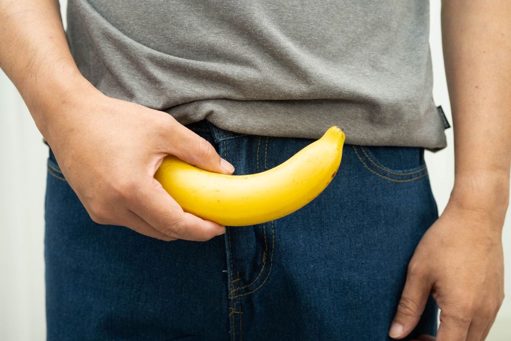 Imagem ilustrativa de banana curvada representando doença de Peyronie e placa peniana na região íntima masculina.