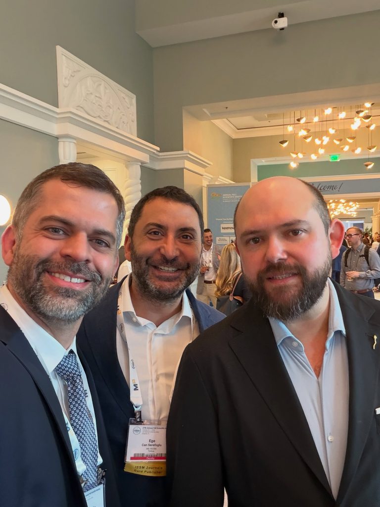 Por que a presença no SMSNA 2026 importa para o paciente? Dr. Marco Túlio Cavalcanti aparece ao lado de dois médicos durante encontro profissional em um congresso internacional de medicina, em ambiente de networking científico.